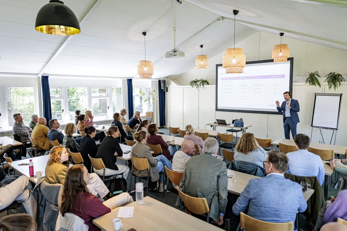 Trainer presenteert AI-toepassingen voor crisisorganisaties aan een volle zaal